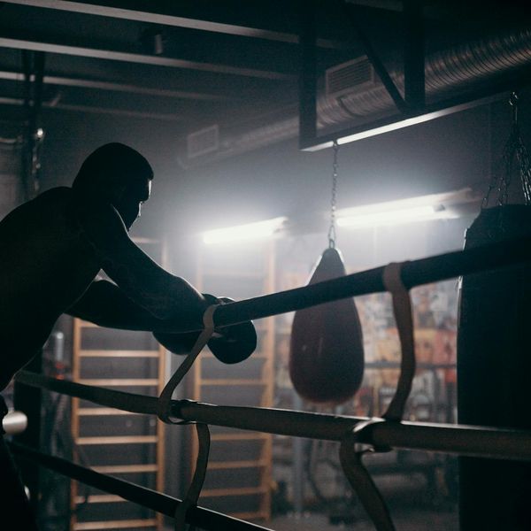 A focused man doing a strength exercise with concentration.